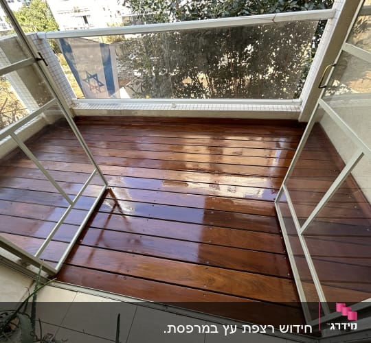 מרפסת עץ עם דלתות זכוכית פתוחות